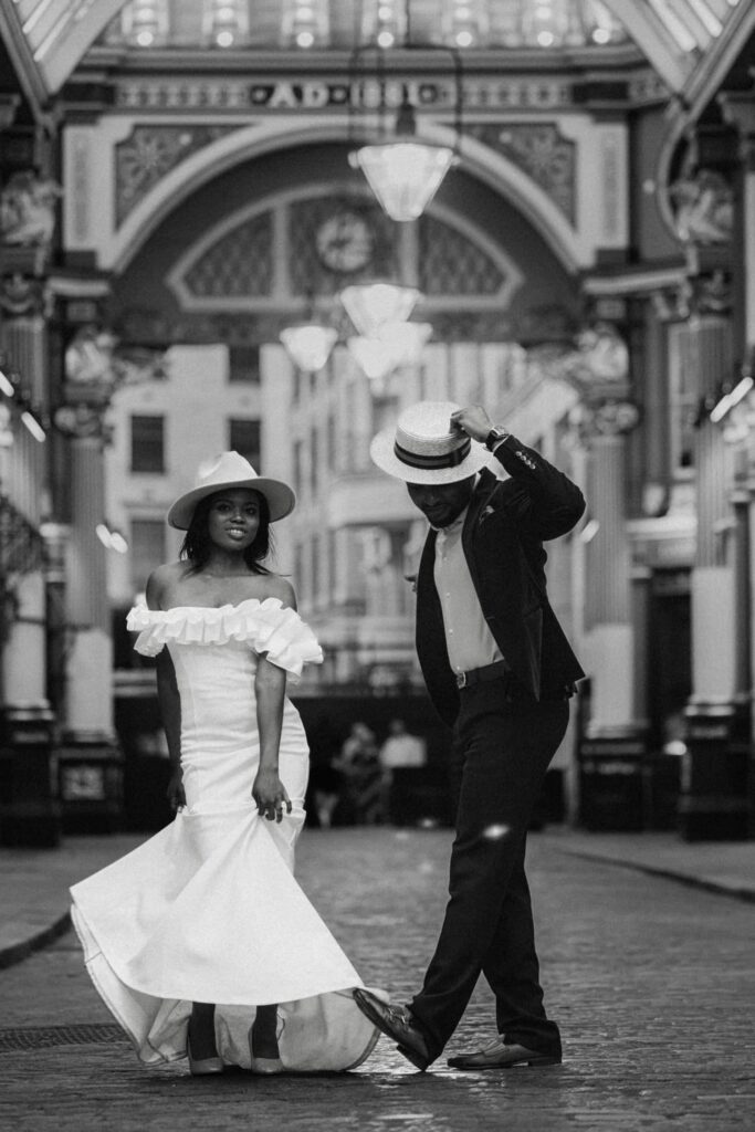 Stylish bride and groom walking in Leadenhall Market, London, black and white photo by a London wedding photographer.