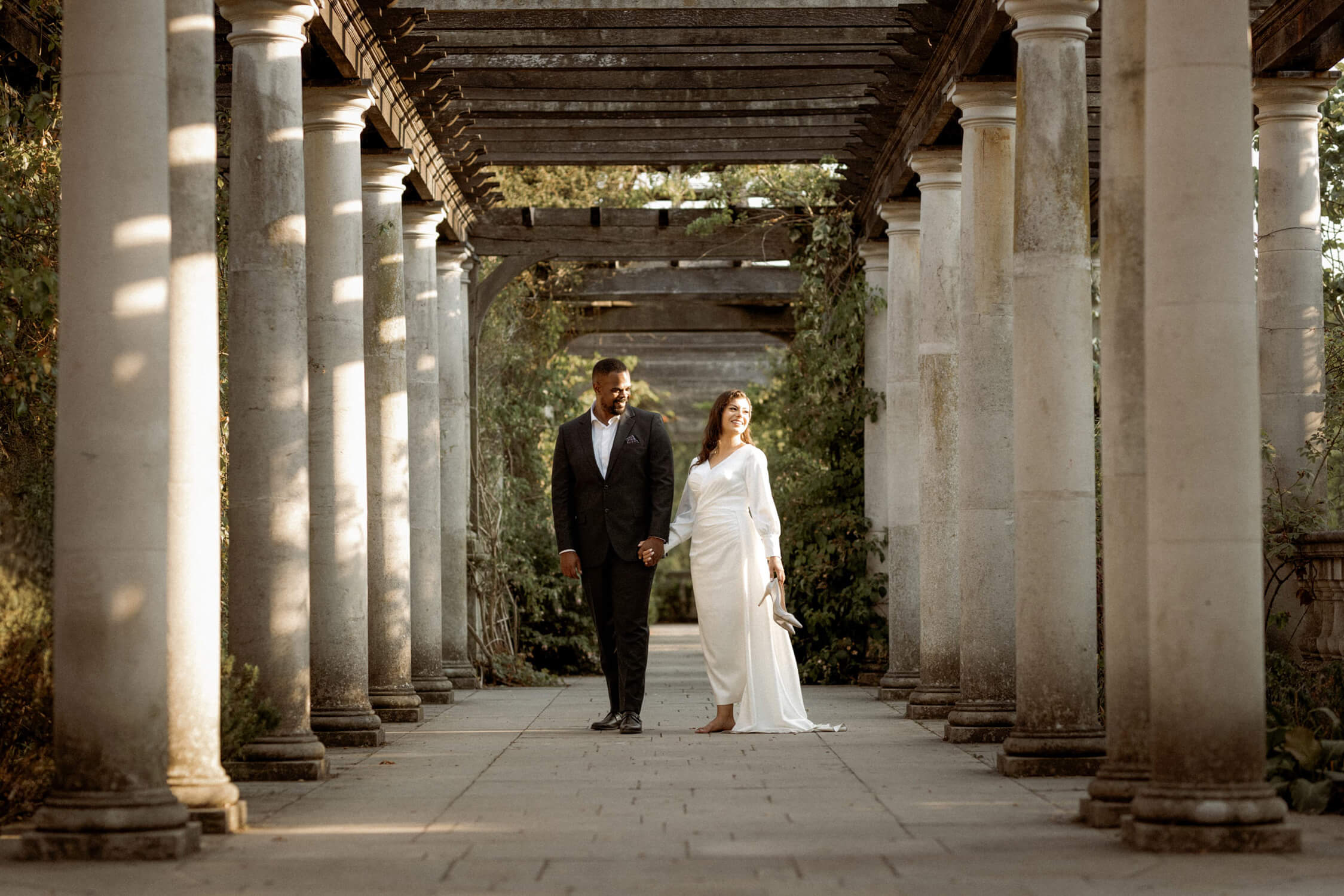 Couple walking hand in hand through Pergola and Hill Garden, one of the best places to elope in London.