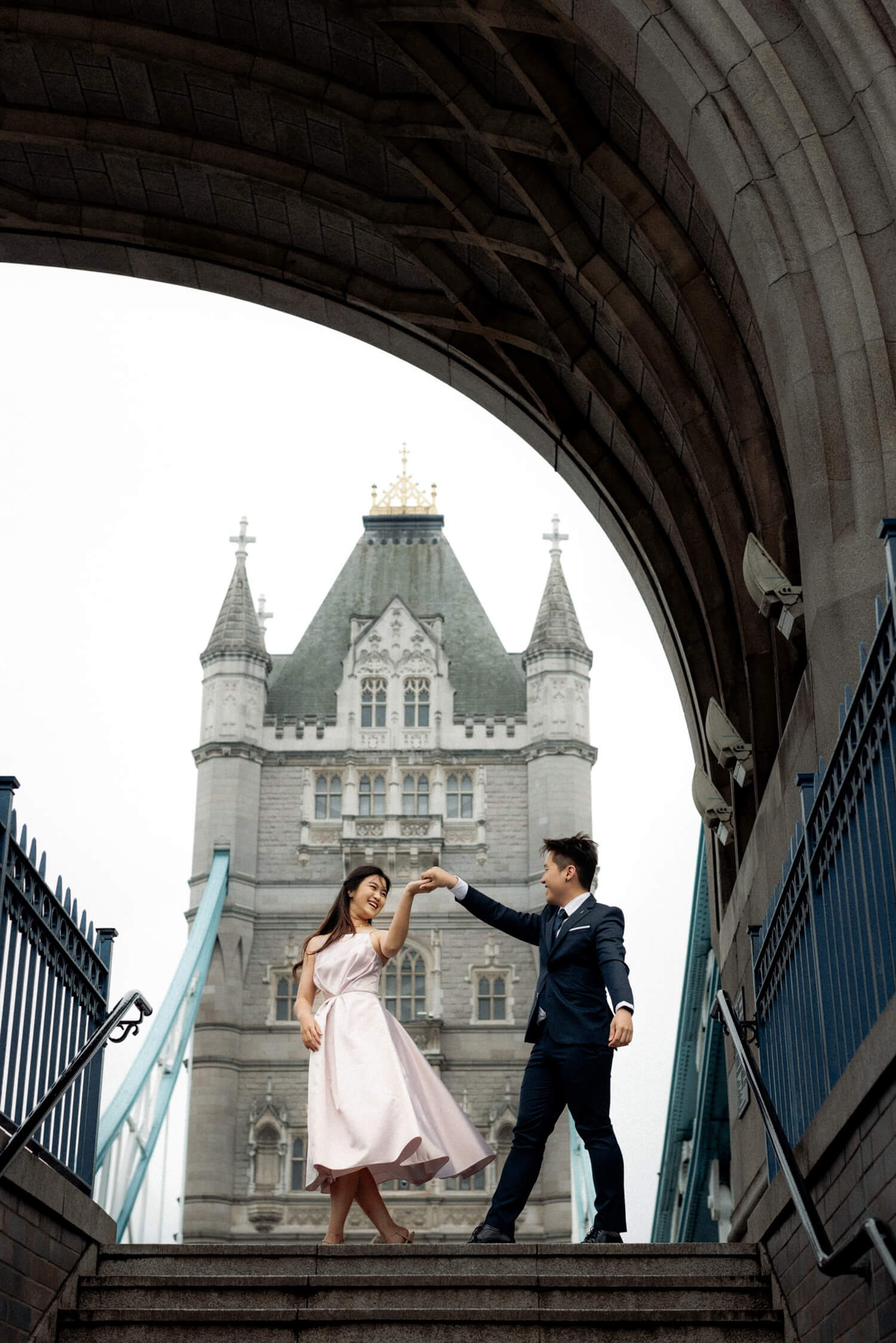 Couple dancing beneath Tower Bridge archway, showcasing one of the best places to elope in London.