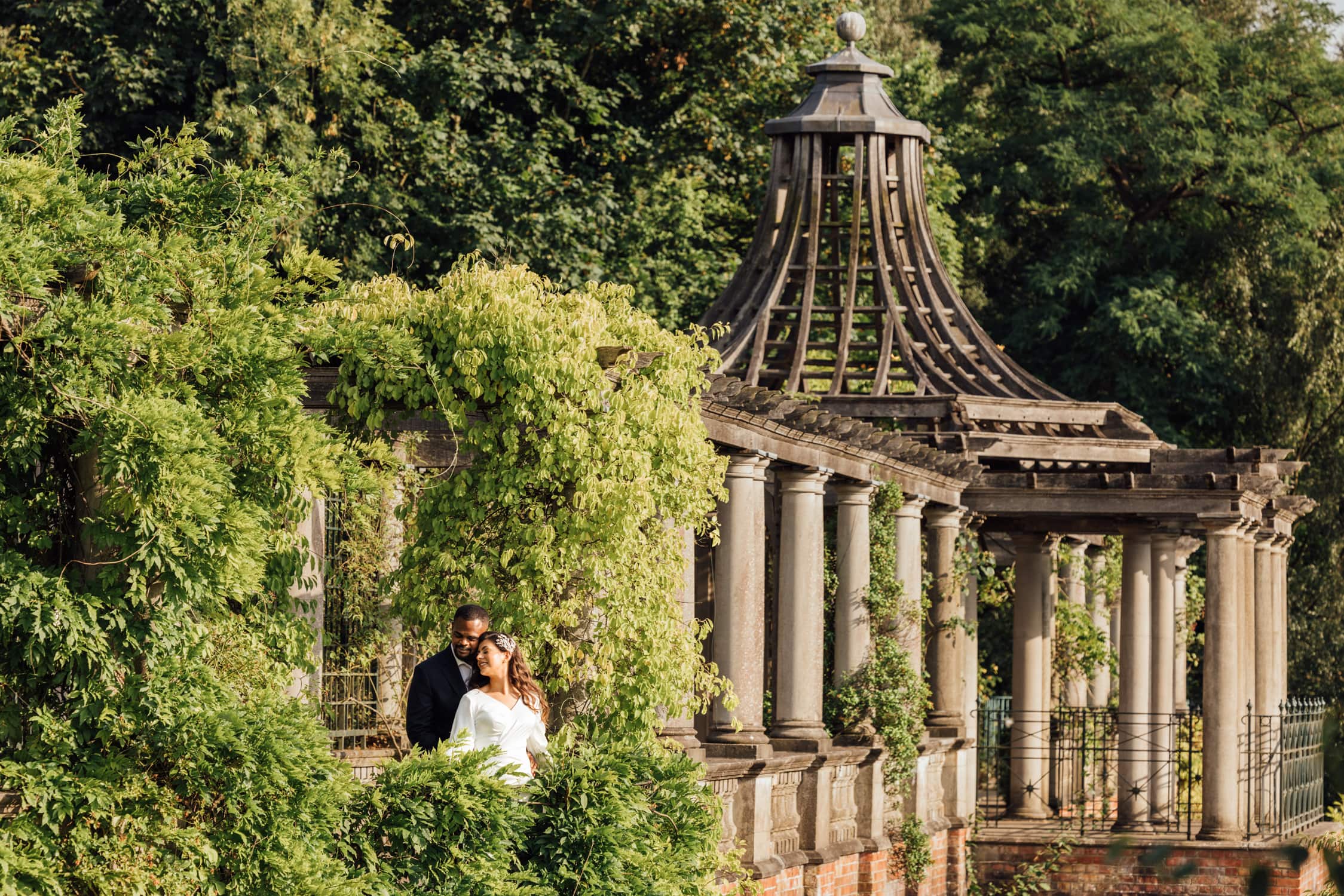 Couple embracing among greenery at Pergola and Hills Garden during a pre-wedding photoshoot in London.