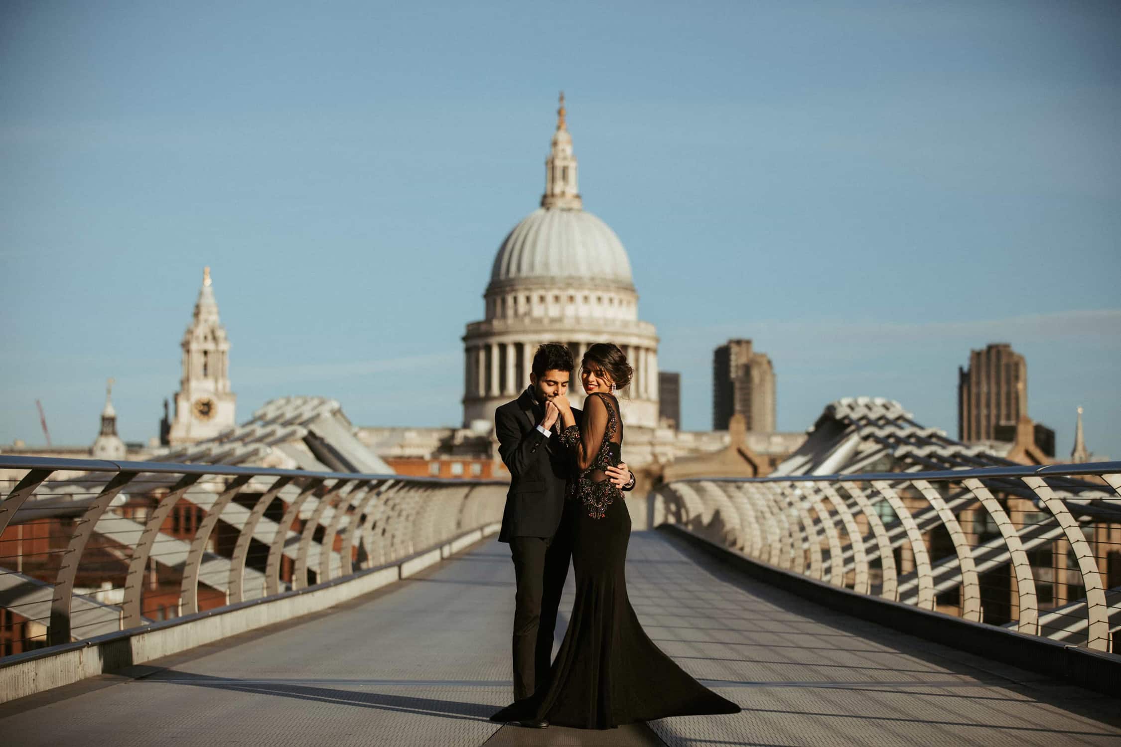 Elegant couple posing on Millennium Bridge with St Paul’s Cathedral during a London micro wedding photoshoot.